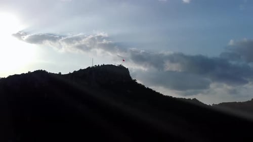 Mountain Peak with Flag and Sunbeams