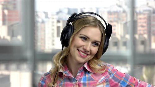 Smiling Woman Listening Music With Headphones Indoors