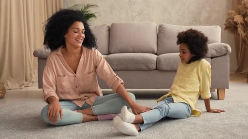 Happy Mother Giving Gift to Child in Living Room