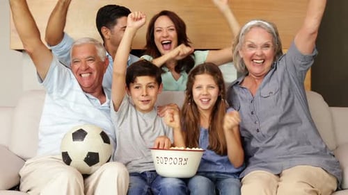 Família feliz assistindo futebol na tv