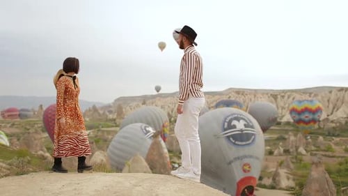 A couple Of Bloggers Standing in front of The Air Balloons. Cappadocia, Turkey