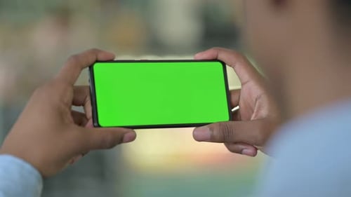 African Man Looking at Green Chrome Key Screen of Smartphone