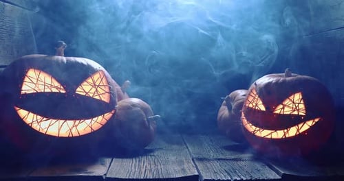 Halloween Pumpkins Glowing on Wooden Surface with Smoky Fog