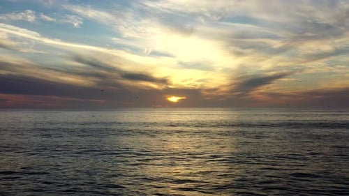 Flying Over Scenic Ocean With Dramatic Sunset Sky - aerial drone shot
