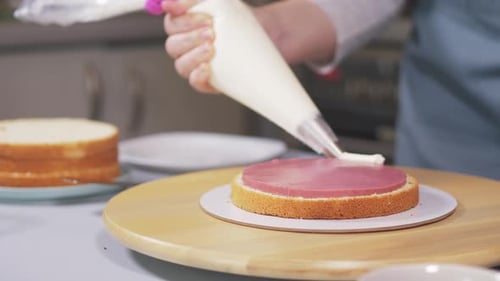 Baker Piping Frosting on Delicious Cake