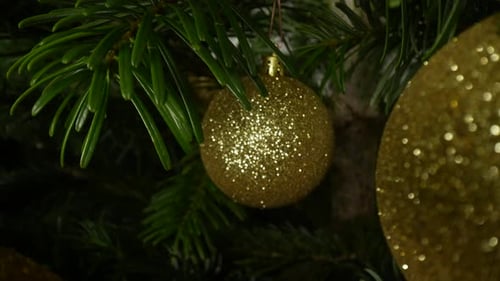 Golden Christmas Baubles Hanging from a Christmas Tree