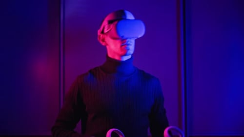 Man Experiences Virtual Reality with Headset and Controllers