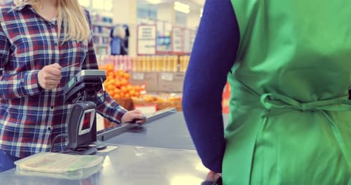Girl Pays the Products at the Checkout with a Bank Card