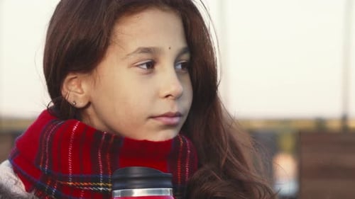 Child Drinking From Red Thermos Close Up