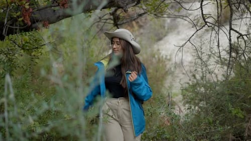 Lone Young Darkhaired Explorer Woman Walks Through Forest Close Pan