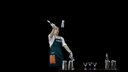 Bartender Juggling Bottle and Shaker on Black Background