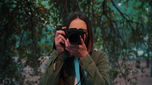 Girl in nature taking frontal photo looking at camera, Close-up portrait, handheld