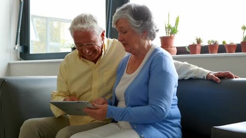 Senior Couple Enjoying Tablet Device Together at Home