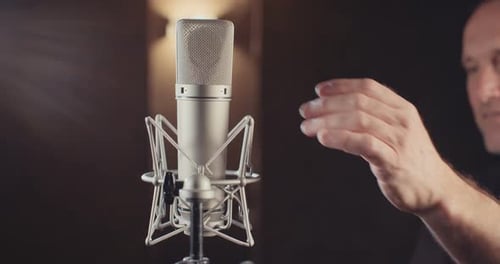 Sound engineer working in a recording studio with a sound console and microphones