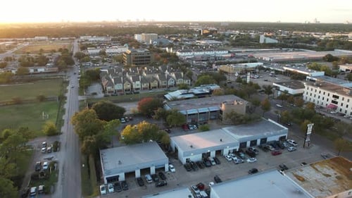 Ascending view of the city while the sun is going down. School fields, streets and cars give this co