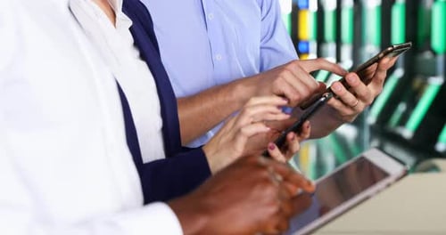 Three People Using Mobile Technology Indoors