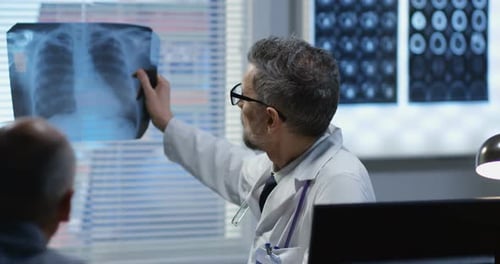 Doctor Discusses X-Ray with Patient in Office