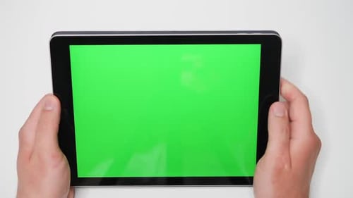 Close Up of Hands Holding a Tablet PC with Green Mockup Screen