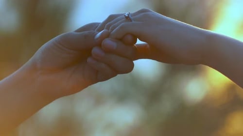 Engagement Ring Placed on Woman's Finger at Sunset