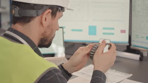 Ingenieur untersucht mechanische Teile von Geräten im Büro