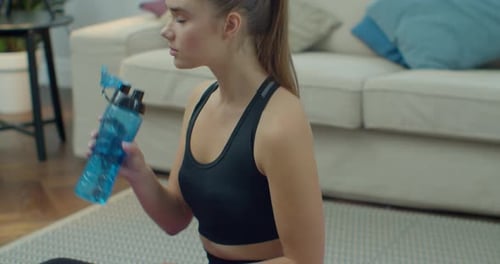 Young Woman Drinking Water After Workout