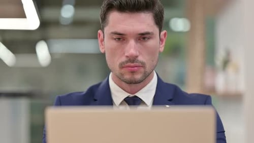 Close Up of Focused Businessman Working on Laptop