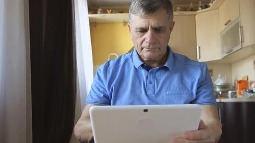 Man Indoors With Tablet At Home