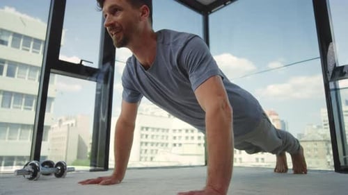 Man Exercising with Pushups in Sunny Apartment
