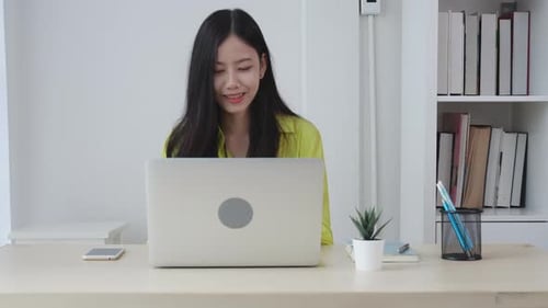 Young asian businesswoman working on laptop computer on desk at home office.