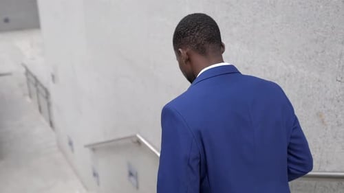 Man in Suit Walking Down Urban Steps