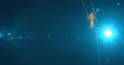 Woman Performing Acrobatics on a Swing at Night