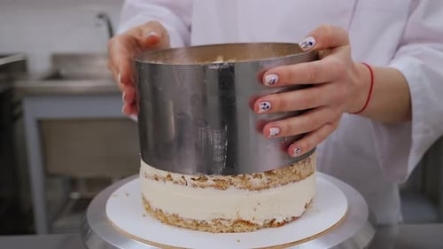 Le chef pâtissier préparant un gâteau dans une pâtisserie prend une forme ronde en métal