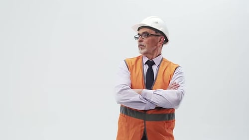 Ein erwachsener Ingenieur in Arbeitsuniform und Helm legt die Hände auf die Brust und schaut zur Seite.