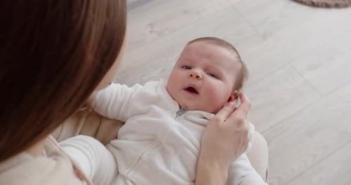 Brown Haired Parent Holding Baby Indoors