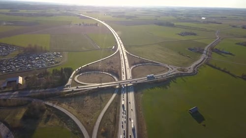 Aerial view of freeway intersection with moving traffic cars.