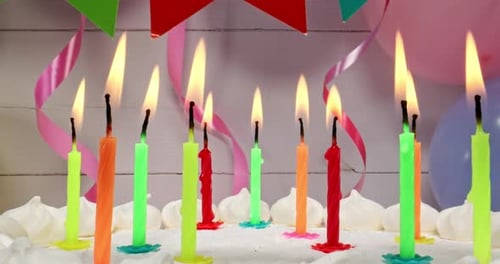 Celebratory Cake with Bright Candles and Party Decorations