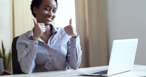 Woman at Laptop Gives Two Thumbs Up