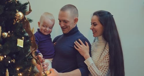 Loving Family Decorates Christmas Tree in Home
