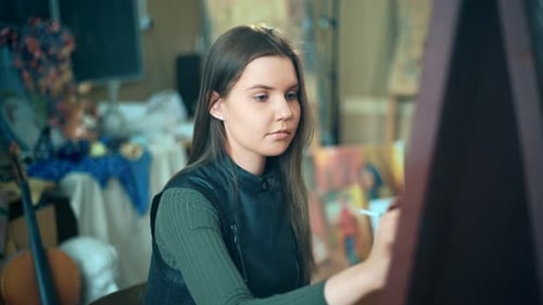 Artist Paints Picture on Canvas with Oil Paints in Her Workshop