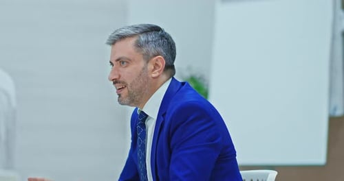 Businessman in Blue Suit Talking in Meeting