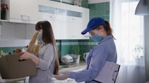 Woman Receives Masked Grocery Delivery in Kitchen