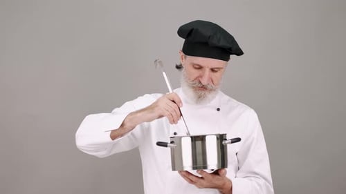 Chef Stirring Pot with Ladle in Studio