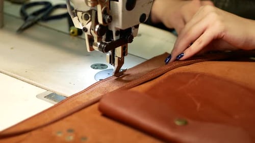Seamstress Sews Leather Bag in a Sewing Workshop. Woman Operates Sewing Machine