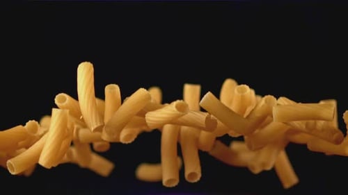 Uncooked Rigatoni Pasta Pieces Fly in Slow Motion