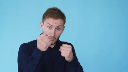 Man Making Boxing Gestures on Light Blue Background