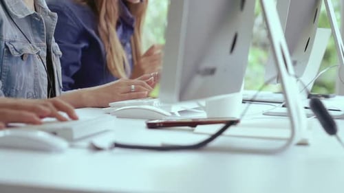 Nahaufnahme einer Geschäftsfrau, die auf dem Schreibtisch mit der Hand tippt und am Computer arbeitet