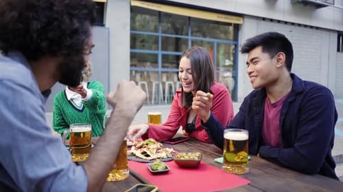 Group Of Friends Having Fun Enjoying Evening Drinks and Food In Bar