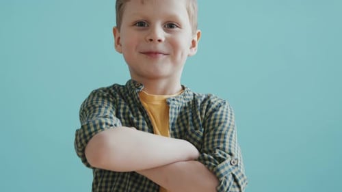 Smiling Blond Boy Poses with Arms Crossed