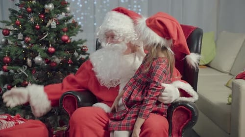 Santa Claus Giving Gift to Child by Christmas Tree