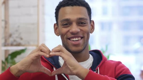 Man Smiling with Hand Heart Gesture
